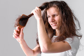 Woman struggling to brush hair